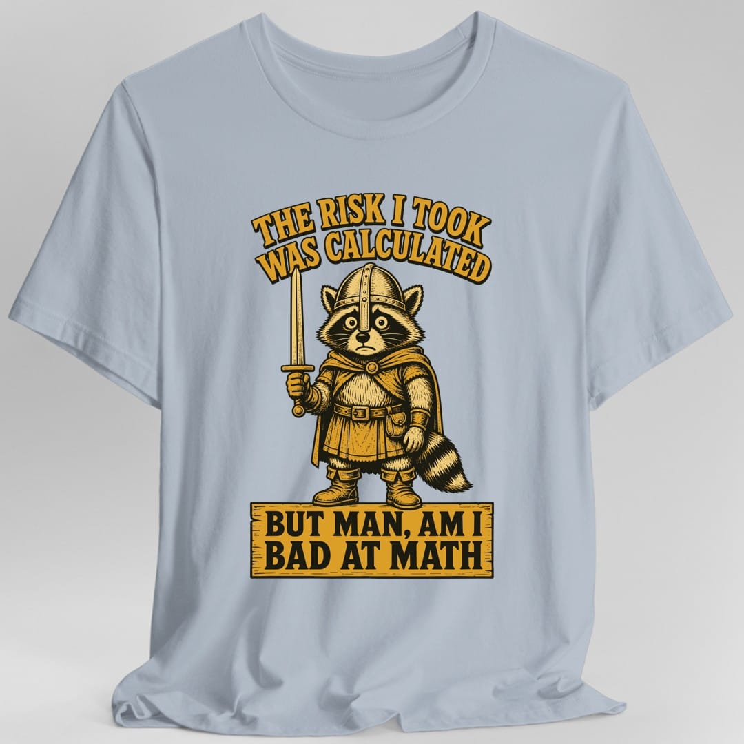 The same Risk Was Calculated raccoon design, on a light blue t-shirt.
