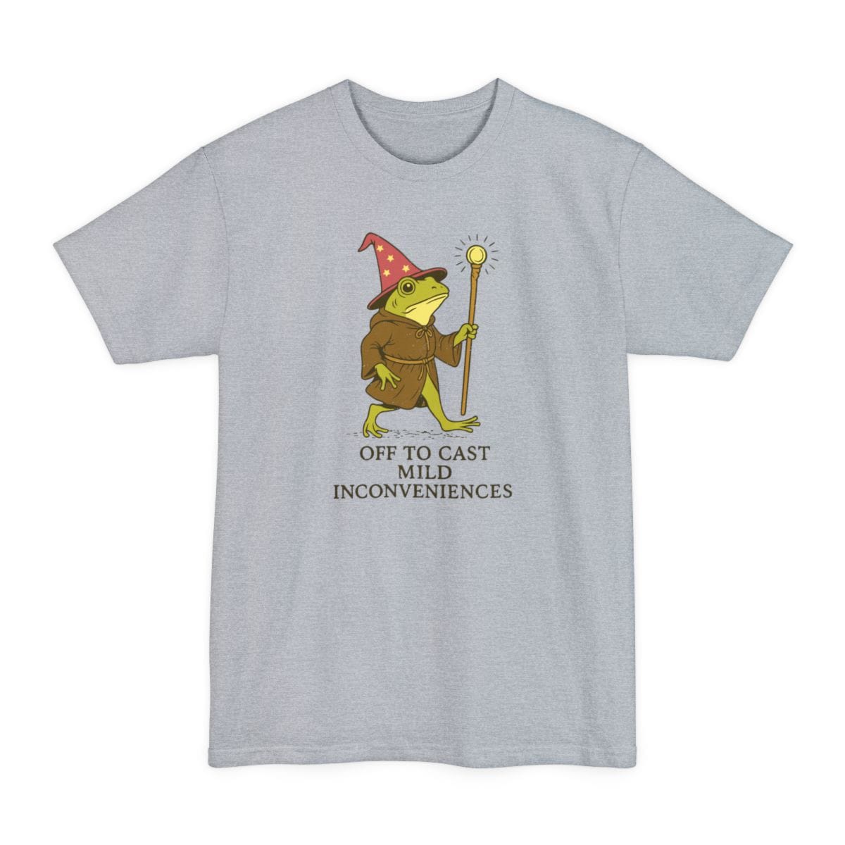 Light Steel tall t-shirt. A frog stands upright in a brown robe and a tall pointed hat covered in stars, holding a wooden staff with a glowing tip. Underneath, "Off to cast mild inconveniences" on three lines in plain capitals. Soft muted illustration in green, brown and cream.