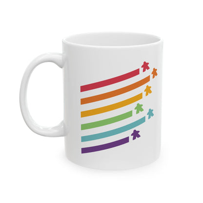 A white ceramic mug featuring a graphic of six rainbow pride stripes with small colorful meeple icons at the end of each stripe, shown on a plain white background.