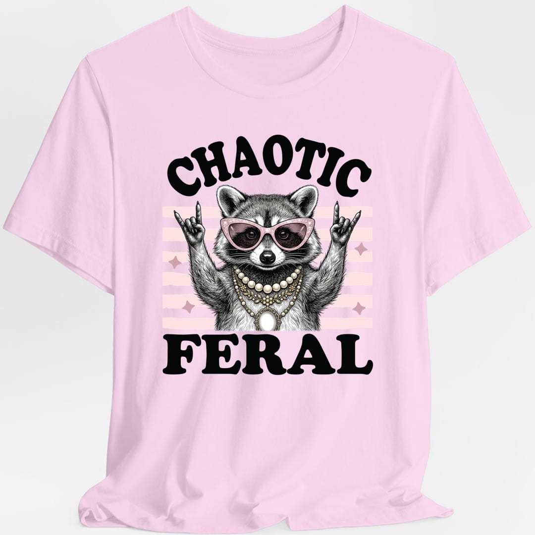 The same Chaotic Feral raccoon design, on a light pink t-shirt.