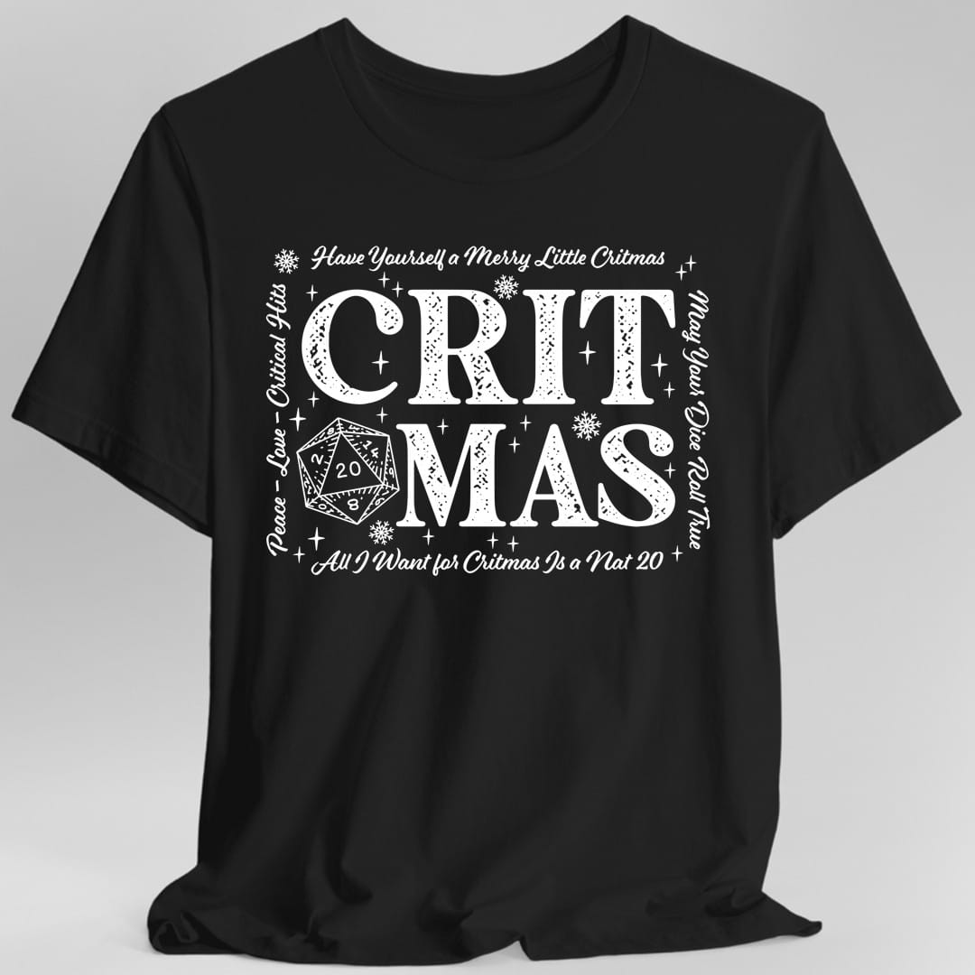 Black t-shirt. The design reads "CRITMAS" in large letters with a twenty-sided die showing 20 tucked into the lower left. Around it in script: "Have Yourself a Merry Little Critmas" across the top, "Peace, Love, Critical Hits" down the left side, "May Your Dice Roll True" down the right, and "All I Want for Critmas Is a Nat 20" along the bottom. Snowflakes and sparkles fill the gaps.