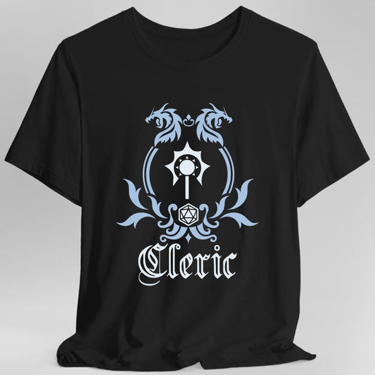 Black t-shirt. A heraldic crest drawn entirely in pale blue and white on a plain background. Two dragons face each other over an arched frame, a spiked mace sits inside the arch, and a twenty-sided die hangs below it between leafy flourishes. Underneath, "Cleric" in an ornate blackletter script.