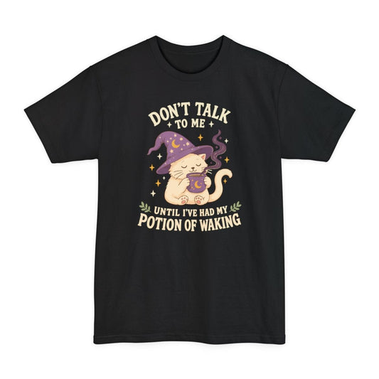 Black tall t-shirt. Reads "Don't talk" across the top with "to me" beneath, and "Until I've had my" and "Potion of waking" across the bottom in cream capitals. Between them a cream cat in a purple starry wizard hat holds a steaming mug in both paws, eyes closed.