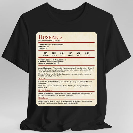 Black t-shirt. Laid out as a Dungeons and Dragons monster stat block on aged parchment, headed "Husband" in dark red with "Medium humanoid, chaotic good" beneath. It lists armor class 13, 55 hit points, speed 30 feet, a full row of ability scores, then Aura of Protection and Honey Do, and actions named Kiss of Life, Fix It, Words of Inspiration and Shield. Dense small text in dark red and black on cream.