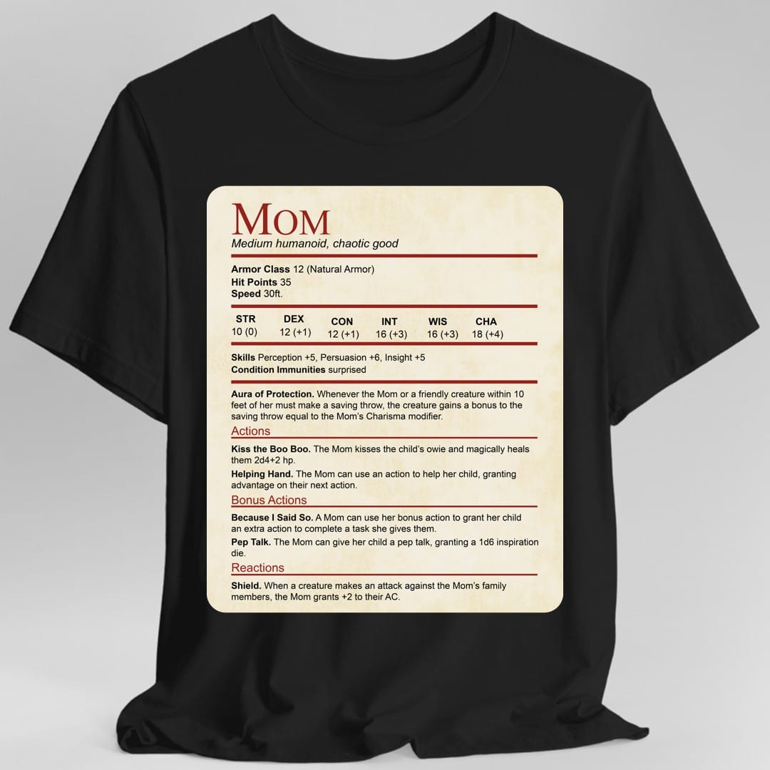 Black t-shirt. Laid out as a Dungeons and Dragons monster stat block on aged parchment, headed "Mom" in dark red with "Medium humanoid, chaotic good" beneath. It lists armor class 12, 35 hit points, speed 30 feet, a full row of ability scores, then Aura of Protection, and actions named Kiss the Boo Boo, Helping Hand, Because I Said So, Pep Talk and Shield. Dense small text in dark red and black on cream.