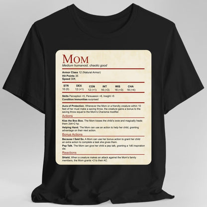 Black t-shirt. Laid out as a Dungeons and Dragons monster stat block on aged parchment, headed "Mom" in dark red with "Medium humanoid, chaotic good" beneath. It lists armor class 12, 35 hit points, speed 30 feet, a full row of ability scores, then Aura of Protection, and actions named Kiss the Boo Boo, Helping Hand, Because I Said So, Pep Talk and Shield. Dense small text in dark red and black on cream.