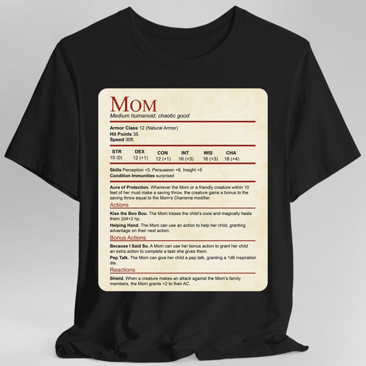 Black t-shirt. Laid out as a Dungeons and Dragons monster stat block on aged parchment, headed "Mom" in dark red with "Medium humanoid, chaotic good" beneath. It lists armor class 12, 35 hit points, speed 30 feet, a full row of ability scores, then Aura of Protection, and actions named Kiss the Boo Boo, Helping Hand, Because I Said So, Pep Talk and Shield. Dense small text in dark red and black on cream.