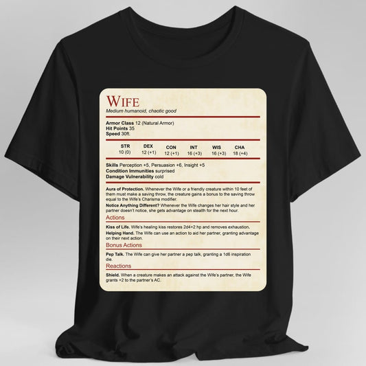 Black t-shirt. Laid out as a Dungeons and Dragons monster stat block on aged parchment, headed "Wife" in dark red with "Medium humanoid, chaotic good" beneath. It lists armor class 12, 35 hit points, speed 30 feet, a full row of ability scores, then Aura of Protection and Notice Anything Different, and actions named Kiss of Life, Helping Hand, Pep Talk and Shield. Dense small text in dark red and black on cream.