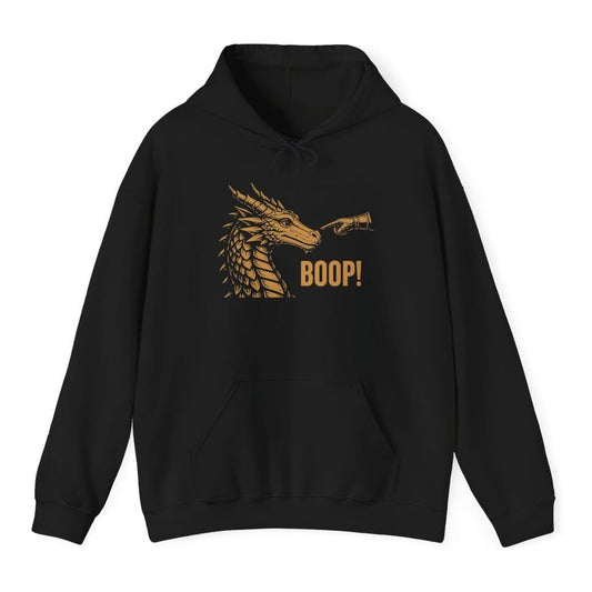 Black hoodie. A dragon head in profile faces right with its horns swept back and jaws closed, drawn in fine engraved lines. A hand in an armored gauntlet reaches in from the right and presses one finger to the tip of its snout, and "Boop!" sits below in bold capitals. Gold on dark colors, dark brown on light ones.
