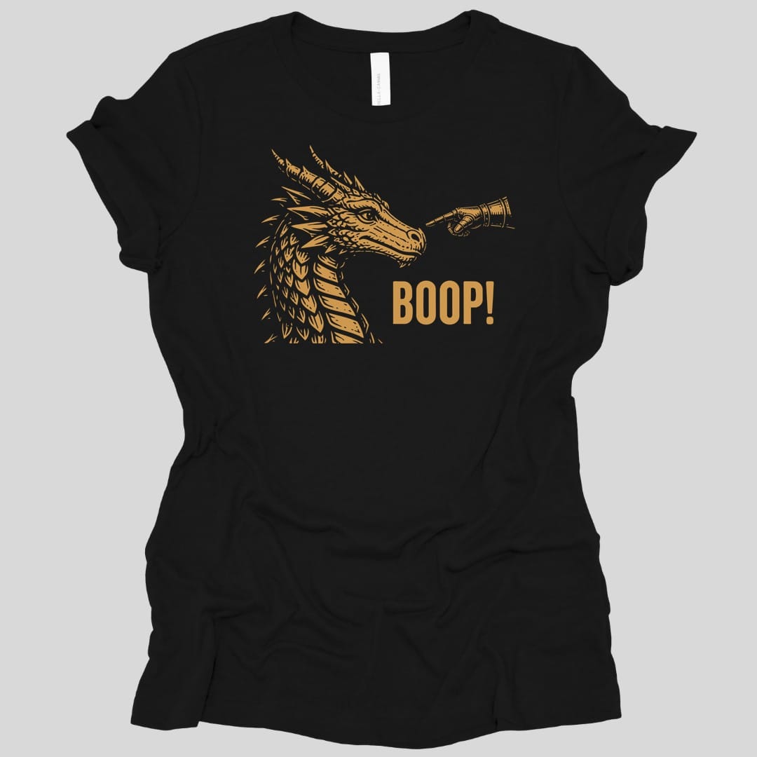 Black t-shirt. A gold dragon head in profile faces right with its horns swept back and jaws closed, drawn in fine engraved lines. A hand reaches in from the right and presses a finger to the tip of its snout. Beneath, "Boop!" in gold capitals.