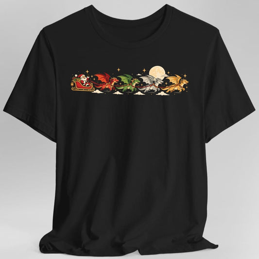 Black t-shirt. Santa waves from a red and gold sleigh piled with gifts, pulled across the night sky by four dragons harnessed in a row in jingle bell collars. The dragons are red, green, silver and gold with their wings spread. A full cream moon, gold stars and small clouds fill the space behind them. Full color cartoon illustration in a wide band across the chest, no words.