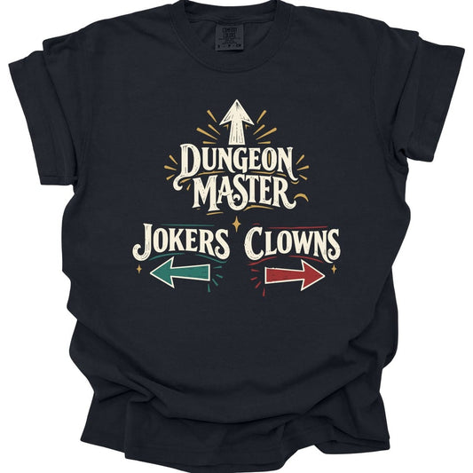 Black t-shirt. The design reads "Dungeon Master" in large vintage circus lettering, with an arrow pointing straight up above it. Below, "Jokers" sits on the left with a teal arrow pointing left, and "Clowns" on the right with a red arrow pointing right. Small gold sparkles and radiating lines surround the words. Cream lettering with teal, red and gold accents in a retro sign style.