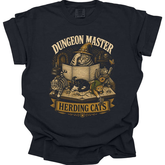Black t-shirt. The design reads Dungeon Master across the top and Herding Cats on a banner at the bottom. In the middle a tired tabby cat in a tall wizard hat sits behind an open game master's screen with one paw to its head, while four cats ignore the game on the map below: one in a knight helmet, one asleep in a wizard hat, one in a green hood pushing a little figure off the table, and one playing a lute. Gold and cream woodcut.