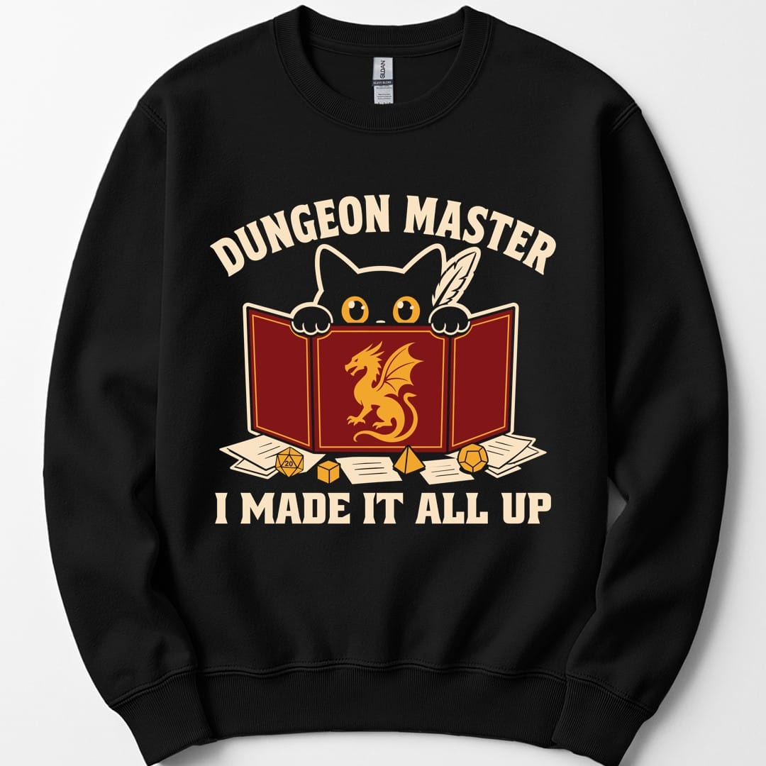 Black sweatshirt. Reads "Dungeon Master" curving across the top in cream capitals. Below, a white cat peers over the top of a dark red dungeon master screen with a gold dragon printed on it, paws hooked over the edge, papers and dice scattered around. Across the bottom, "I made it all up".