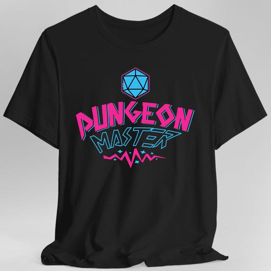 Black t-shirt. A cyan twenty-sided die outlined in pink sits at the top. Below it, "Dungeon" in hot pink outlined capitals over "Master" in pale blue, both slanted and styled like a nineties skate logo, with small pink zigzags and sparks underneath. Bright pink and cyan on a dark background.