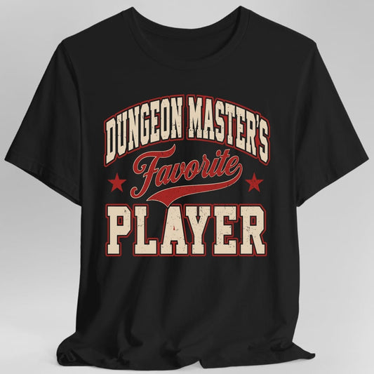 Black t-shirt. The design reads Dungeon Master's Favorite Player. Dungeon Master's is arched across the top in cream block capitals outlined in red, Favorite runs across the middle in red script with a swoosh underline and a small red star on each side, and Player fills the bottom in large cream varsity capitals outlined in red. Worn vintage screen print texture, no picture.