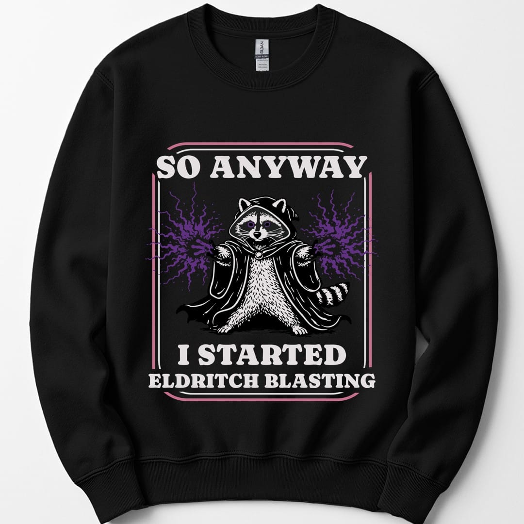Black sweatshirt. Reads "So anyway" across the top in cream capitals and "I started eldritch blasting" across the bottom. Between them a raccoon sits in a dark hooded cloak with both paws raised and purple magic crackling out. A thin pink and cream double frame runs around the whole design.