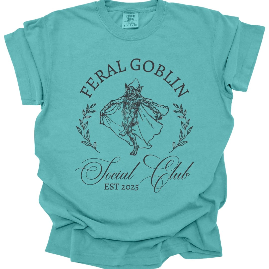 The same Feral Goblin Social Club, cat design, on a seafoam t-shirt.