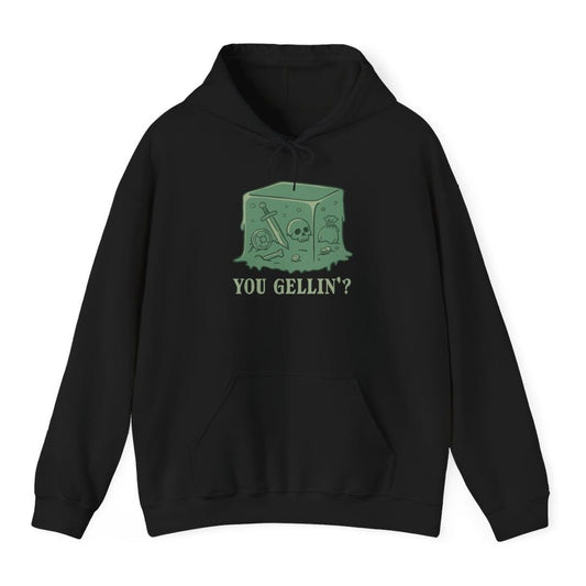 Black hoodie. A translucent green cube of jelly sits in the middle with things suspended inside it: a sword, a skull, a coin pouch, a shield and a few coins. Below it, "You gellin'?" in green capitals. Simple flat cartoon style.