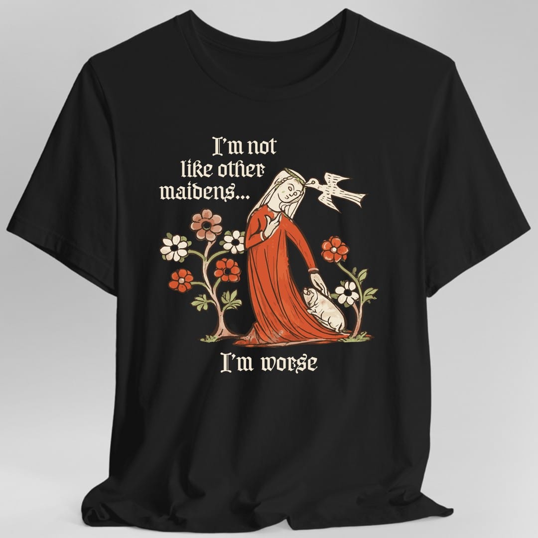 Black t-shirt. The design reads I'm not like other maidens at the top and I'm worse at the bottom, both in blackletter type. Between them a medieval manuscript style woman in a flowing red gown leans forward, one hand resting on a small white dog at her feet while a white bird speaks into her ear. Stylized flowers on slender trees frame her on both sides.