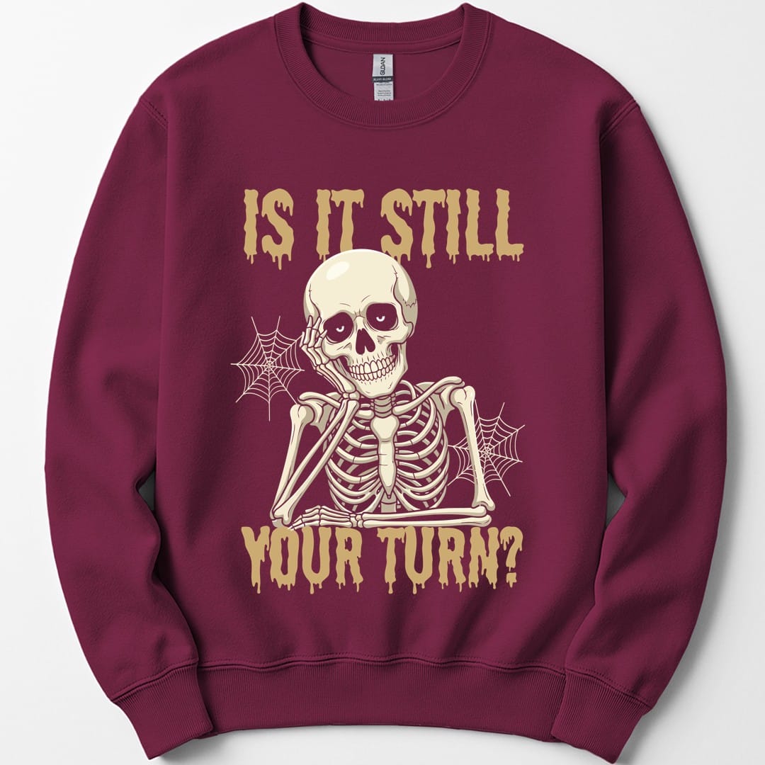 The same Is It Still Your Turn skeleton design, on a maroon sweatshirt.