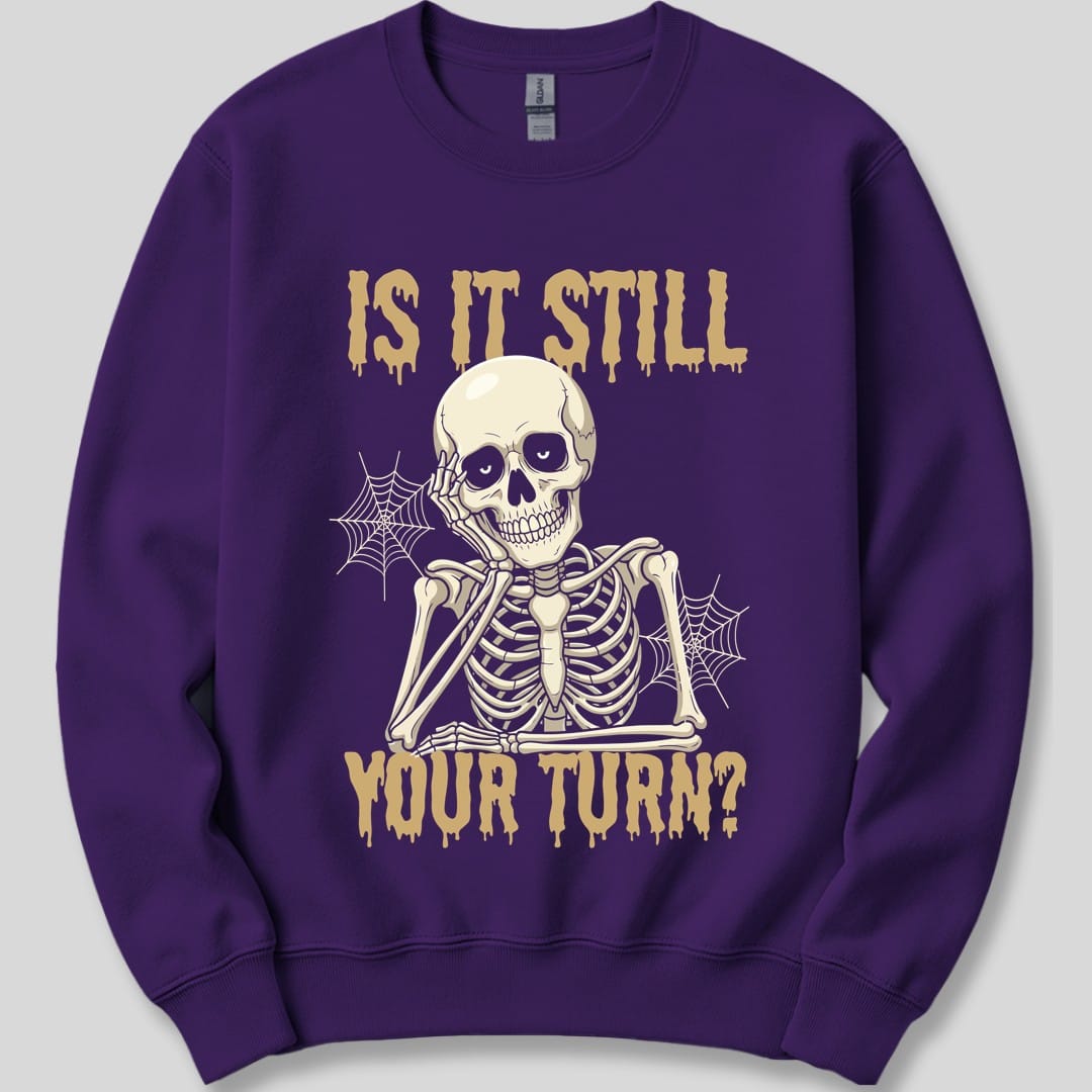 The same Is It Still Your Turn skeleton design, on a purple sweatshirt.