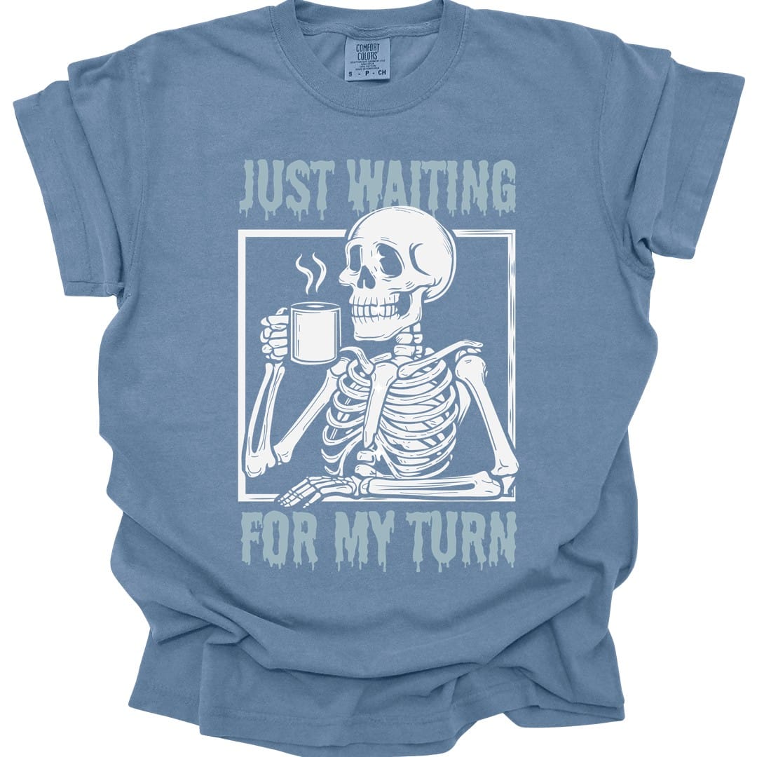 The same Just Waiting For My Turn skeleton design, on a blue jean t-shirt.