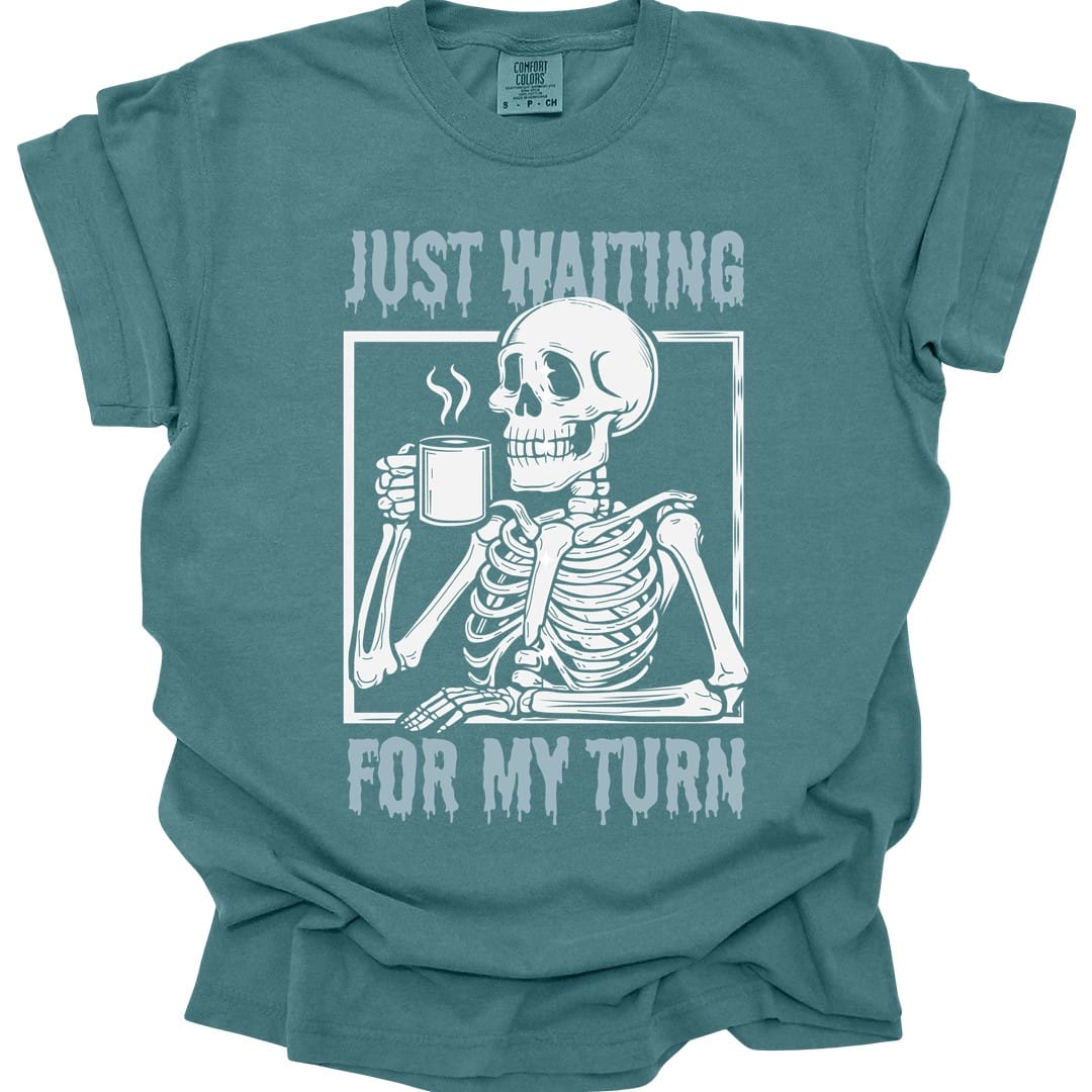 The same Just Waiting For My Turn skeleton design, on a blue spruce t-shirt.