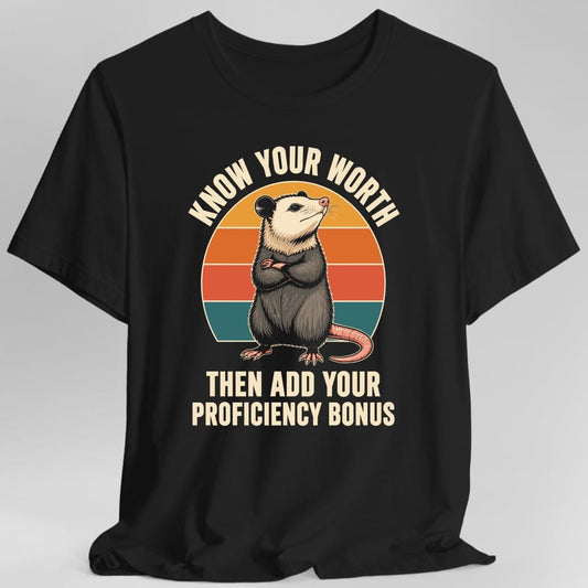 Black t-shirt. The design reads "KNOW YOUR WORTH" curved across the top and "THEN ADD YOUR PROFICIENCY BONUS" in two lines at the bottom, in cream letters. In the middle an opossum stands upright with its arms crossed and its chin lifted, pink nose and long pink tail curling to one side. Behind it is a striped semicircle in gold, orange, red and teal. Drawn in soft realistic detail against flat retro stripes.