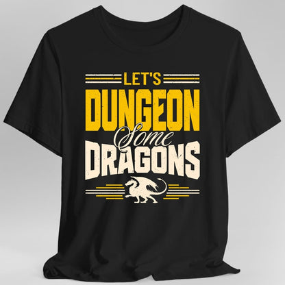 Black t-shirt. Reads "Let's" in gold, "Dungeon" in large gold capitals, "Some" in cream script and "Dragons" in large cream capitals, stacked over four lines. A small gold dragon walks along the bottom with speed lines either side of it, and more lines run above the top word.
