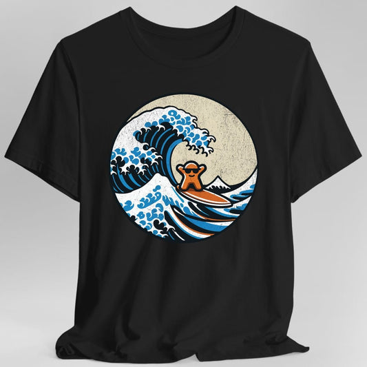 Black t-shirt. A circular design in the style of the Great Wave woodblock print: a big blue and white wave curls over, with Mount Fuji behind and a small orange meeple riding a surfboard down the face of the wave. No words.