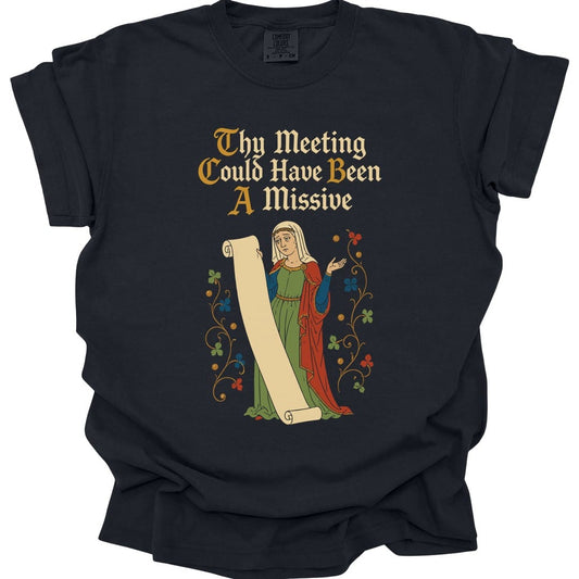 Black t-shirt. Reads "Thy meeting could have been a missive" across four lines in gold and cream blackletter. Below, a woman in a green medieval gown and white headdress stands holding out a long unrolled scroll, framed by curling vines with small flowers.