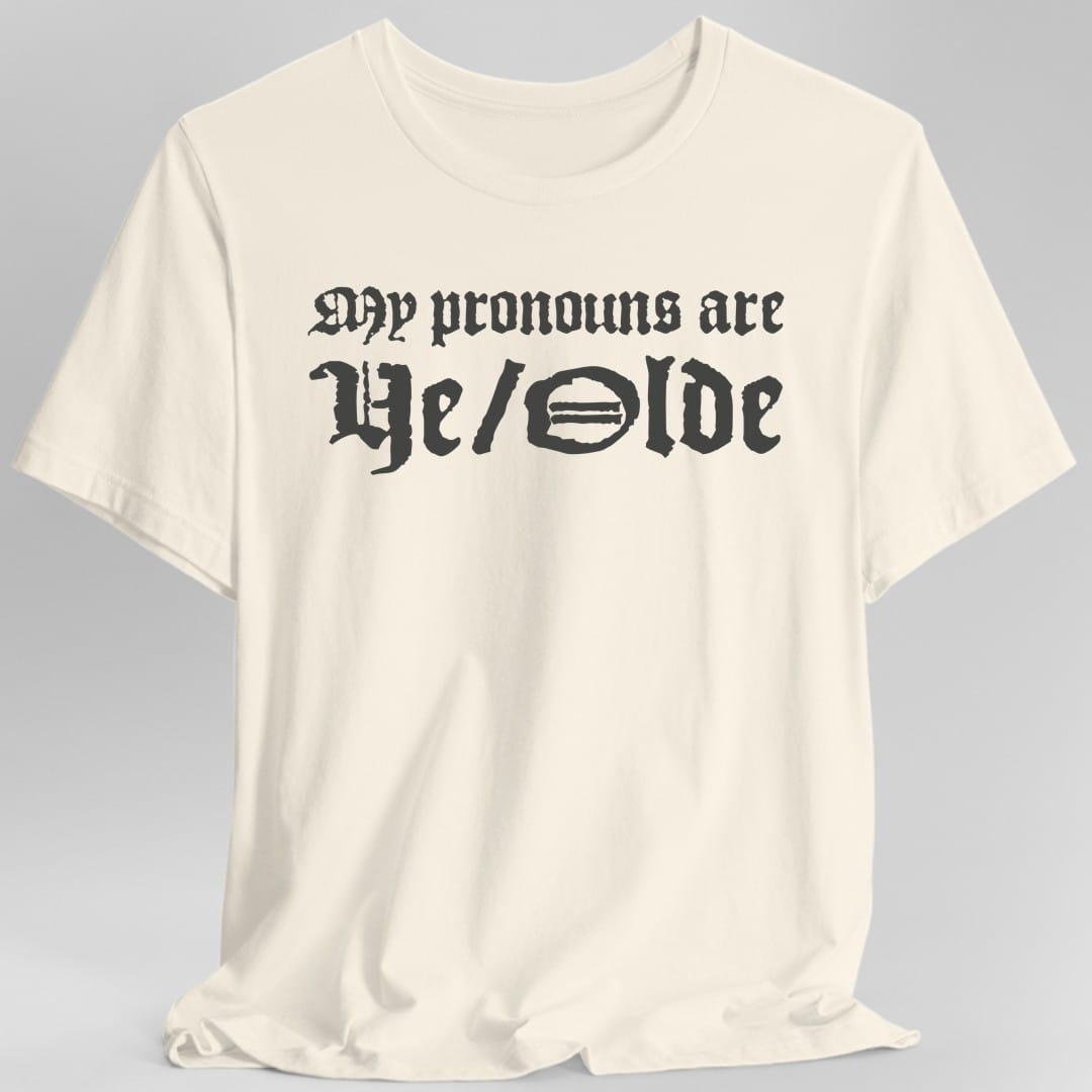 The same My Pronouns Are Ye Olde design, on a natural t-shirt.