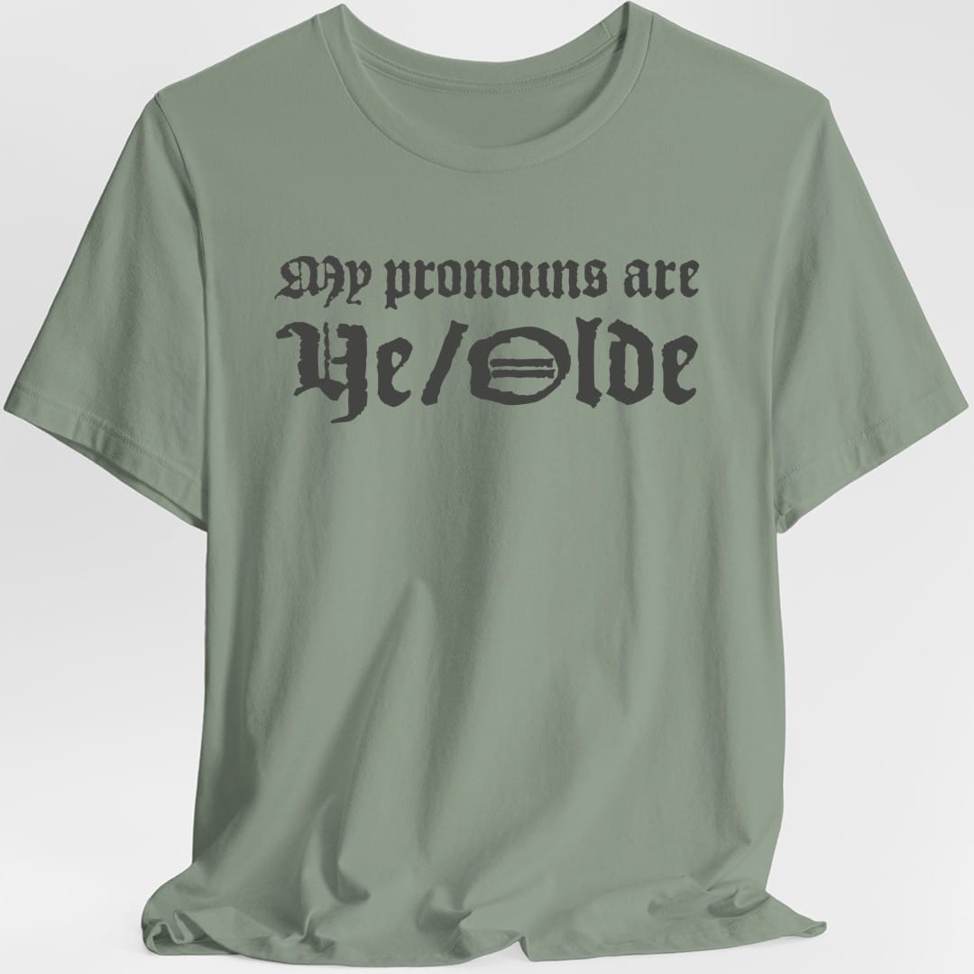 The same My Pronouns Are Ye Olde design, on a sage t-shirt.