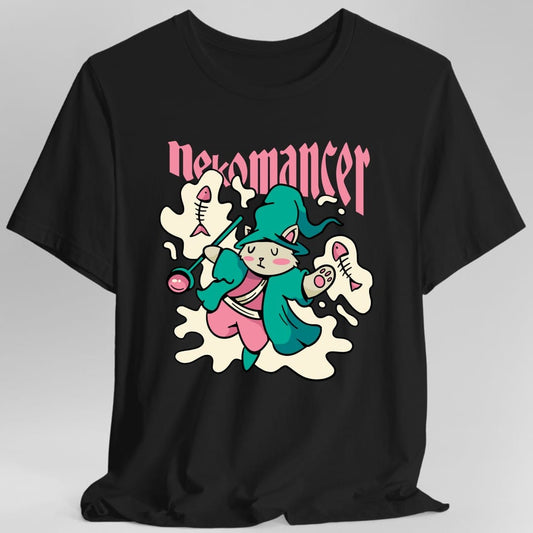 Black t-shirt. Reads "Nekomancer" across the top in pink blackletter. Below, a white cat in a teal hooded robe holds up a staff topped with a pink orb, standing among floating fish skeletons and a pale cloud of magic. Soft cartoon style in teal, pink and cream.