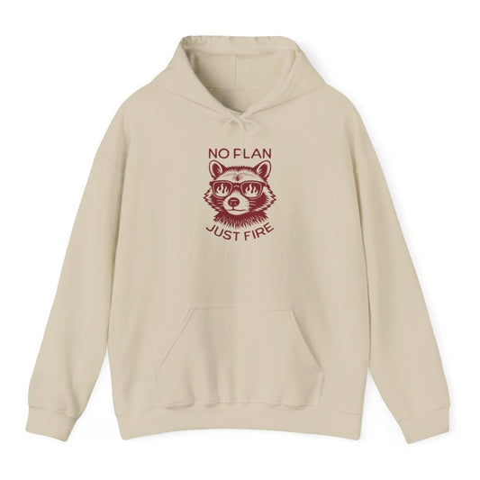 Sand hoodie. Reads "No plan" across the top and "Just fire" across the bottom in dark red capitals. Between them a raccoon faces forward wearing sunglasses with flames reflected in the lenses. Drawn in engraved lines, all in a single deep red.