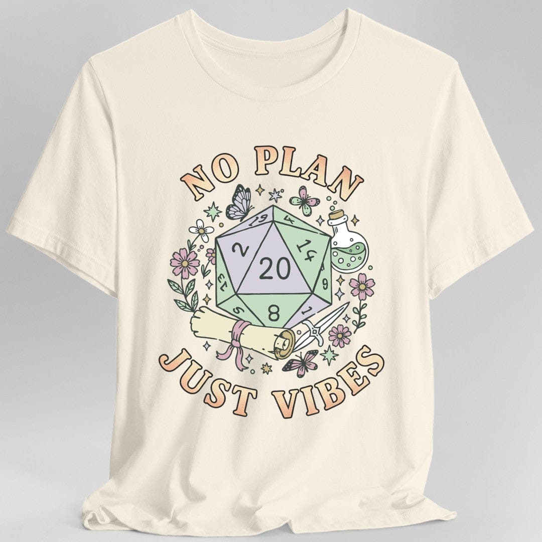 Reads "No Plan" curving across the top and "Just Vibes" curving across the bottom in peach lettering. In the middle sits a large twenty-sided die showing 20, its faces in soft sage green and lilac, ringed by pink cosmos flowers, leaves, butterflies, sparkles, a green potion bottle, a silver dagger and a scroll tied with a pink ribbon. Soft pastel cottagecore illustration.