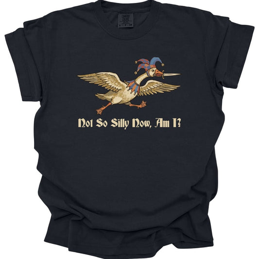 Black t-shirt. A goose flies to the left with its wings spread and neck outstretched, wearing a red and blue jester hat with bells, a sword gripped in its beak. Underneath, "Not So Silly Now, Am I?" in a dark script.