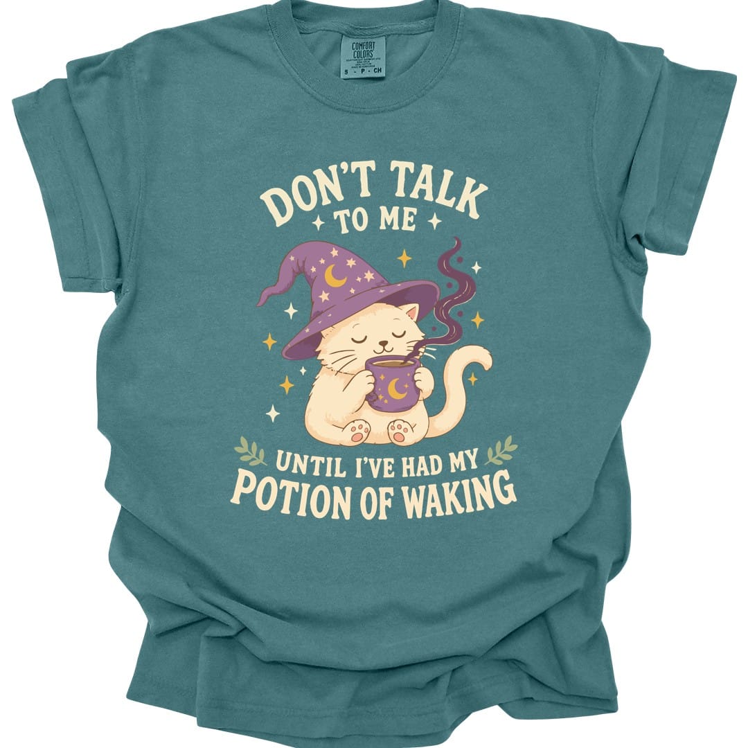 The same Potion Of Waking cat design, on a blue spruce t-shirt.