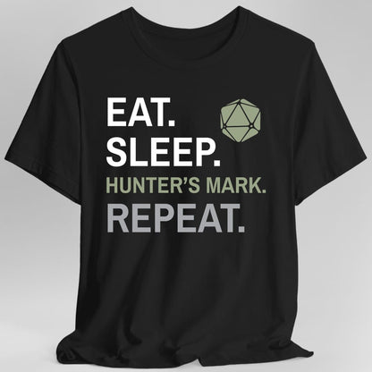 Black t-shirt. Four words stacked in heavy block capitals on four lines: "Eat." and "Sleep." in white, then "Hunter's mark." in olive green, then "Repeat." in gray. A olive green twenty-sided die sits in the top right corner beside the word Eat. All type, no illustration.
