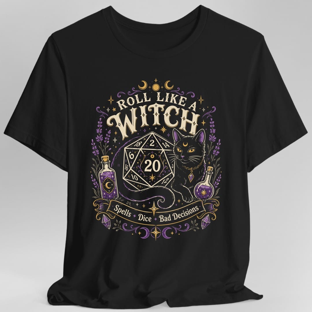 Black t-shirt. Reads "Roll like a" curving across the top and "Witch" in large cream capitals beneath. Below sits a large twenty-sided die showing 20 with a black cat beside it, two potion bottles either side and a banner underneath reading "Spells, dice, bad decisions".