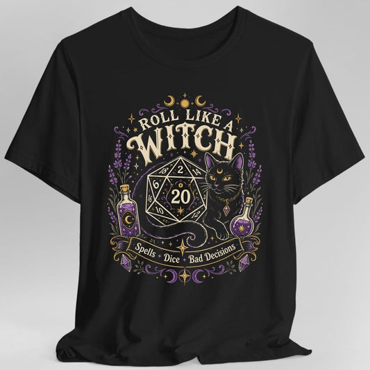 Black t-shirt. Reads "Roll like a" curving across the top and "Witch" in large cream capitals beneath. Below sits a large twenty-sided die showing 20 with a black cat beside it, two potion bottles either side and a banner underneath reading "Spells, dice, bad decisions".
