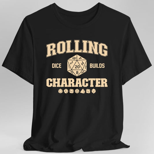 Black t-shirt. The design reads "Rolling" in tall collegiate letters across the top, then "dice" and "builds" either side of a large twenty sided die showing the number 20, then "Character" in bold slab capitals below. A row of seven polyhedral dice sits underneath. Distressed varsity athletic style, printed in a single ink.