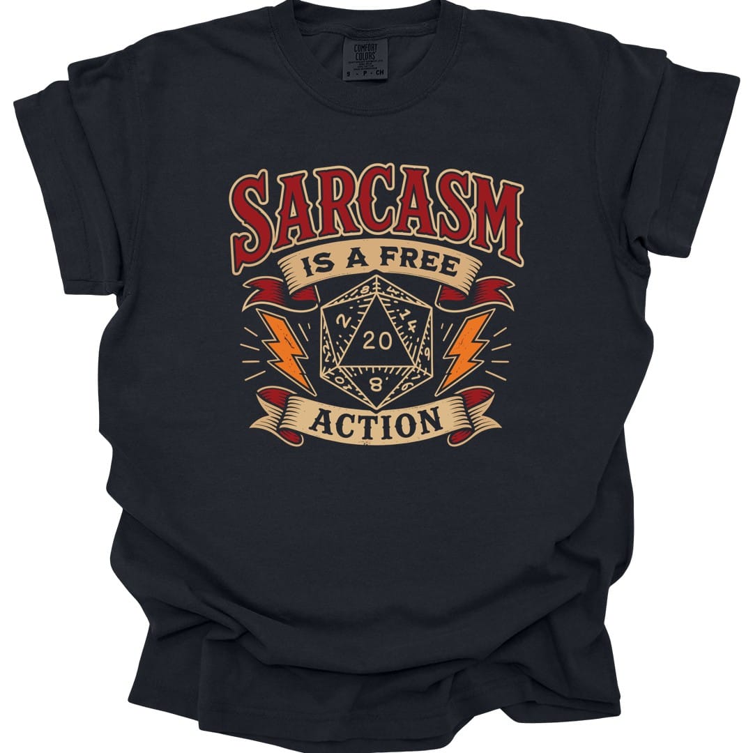 Black t-shirt. Reads "Sarcasm" across the top in dark red capitals, "Is a free" on a cream banner beneath, and "Action" on another banner at the bottom. Between them a cream twenty-sided die showing 20 sits with an orange lightning bolt on each side.