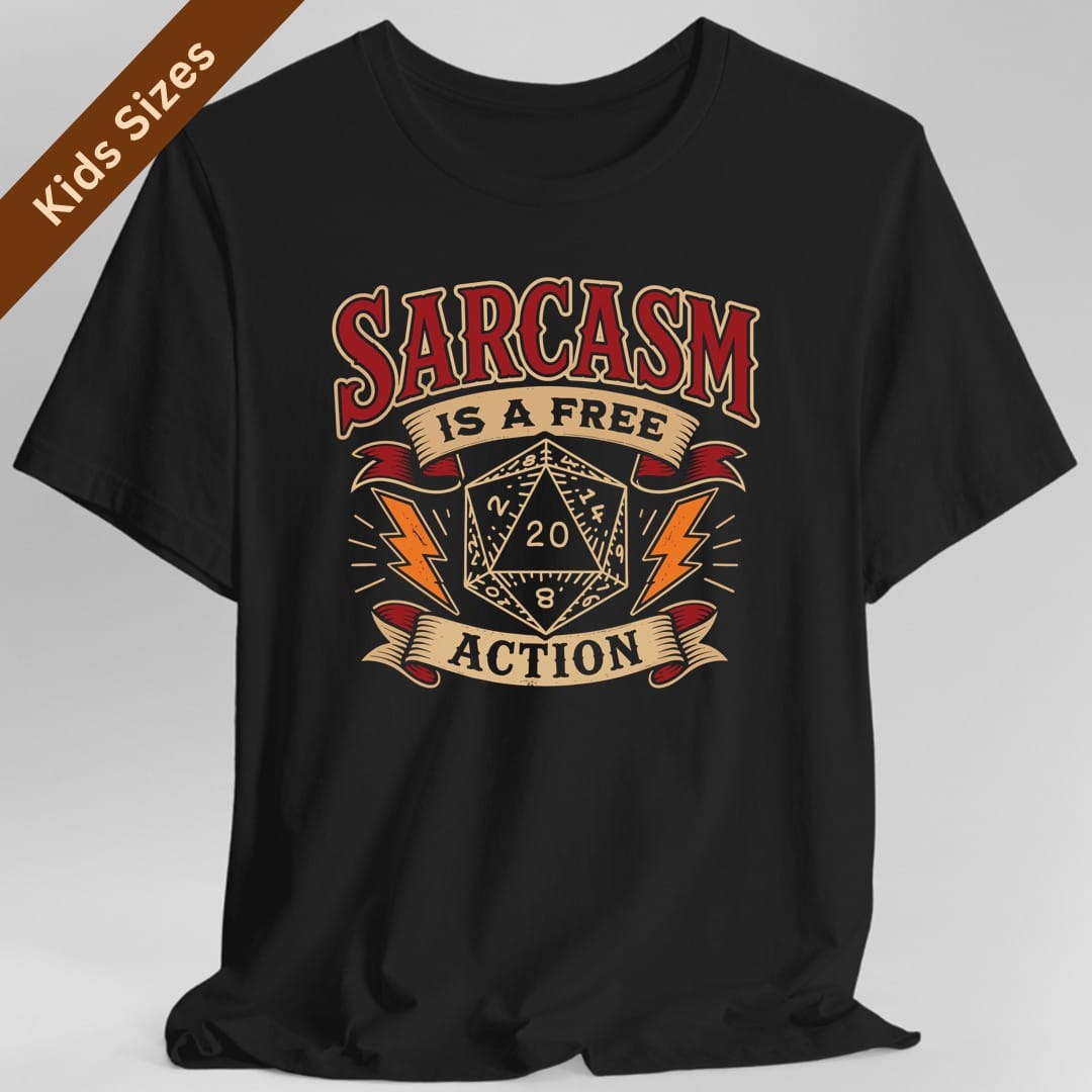 Black kids t-shirt. Reads "Sarcasm" across the top in dark red capitals, "Is a free" on a cream banner beneath, and "Action" on another banner at the bottom. Between them a cream twenty-sided die showing 20 sits with an orange lightning bolt on each side.