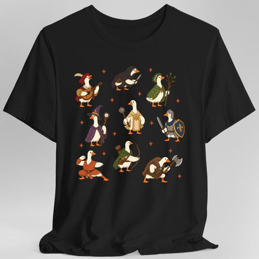 Black t-shirt. Nine white geese in three rows, each dressed as a fantasy adventuring class: a bard in a feathered red hat with a lute, a hooded rogue with a dagger, a druid in leaves with a staff, a wizard in a starry purple cloak, a cleric in gold robes with a mace, a knight with a sword and blue shield, a monk in orange robes, a ranger in a green cloak with a bow, and a barbarian in furs with an axe. Orange sparkles sit between them. No words.