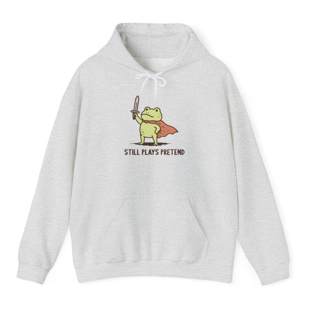 The same Still Plays Pretend frog, small design, on an ash hoodie.
