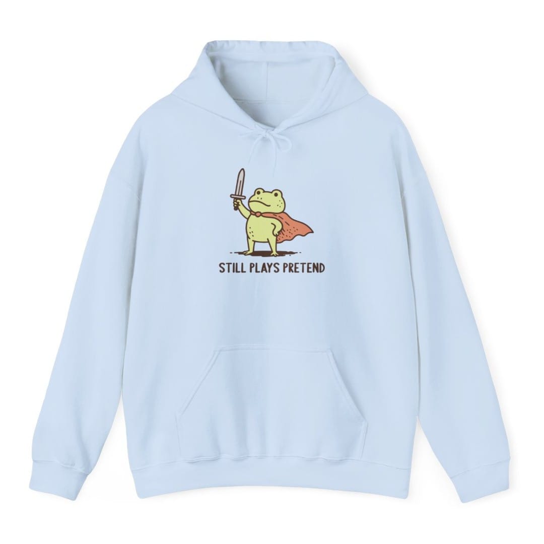 The same Still Plays Pretend frog, small design, on a light blue hoodie.
