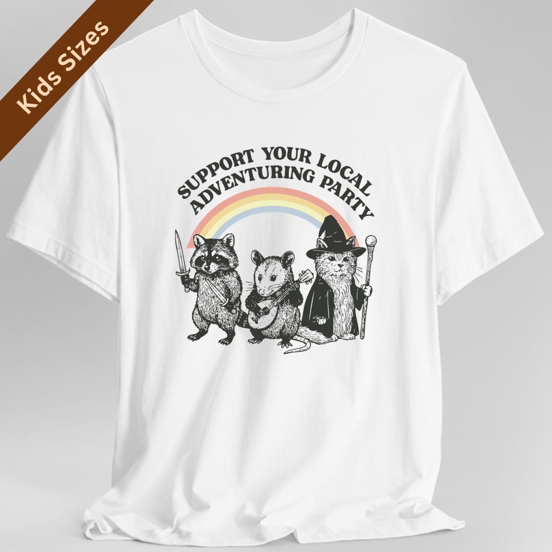 White kids t-shirt. Reads "Support your local adventuring party" curving across the top in dark capitals. Below, three animals stand in a row: a raccoon holding a sword, an opossum with a dagger, and a cat in a pointed wizard hat with a staff. A soft pastel rainbow arcs behind them. Engraved linework over flat pastel color.