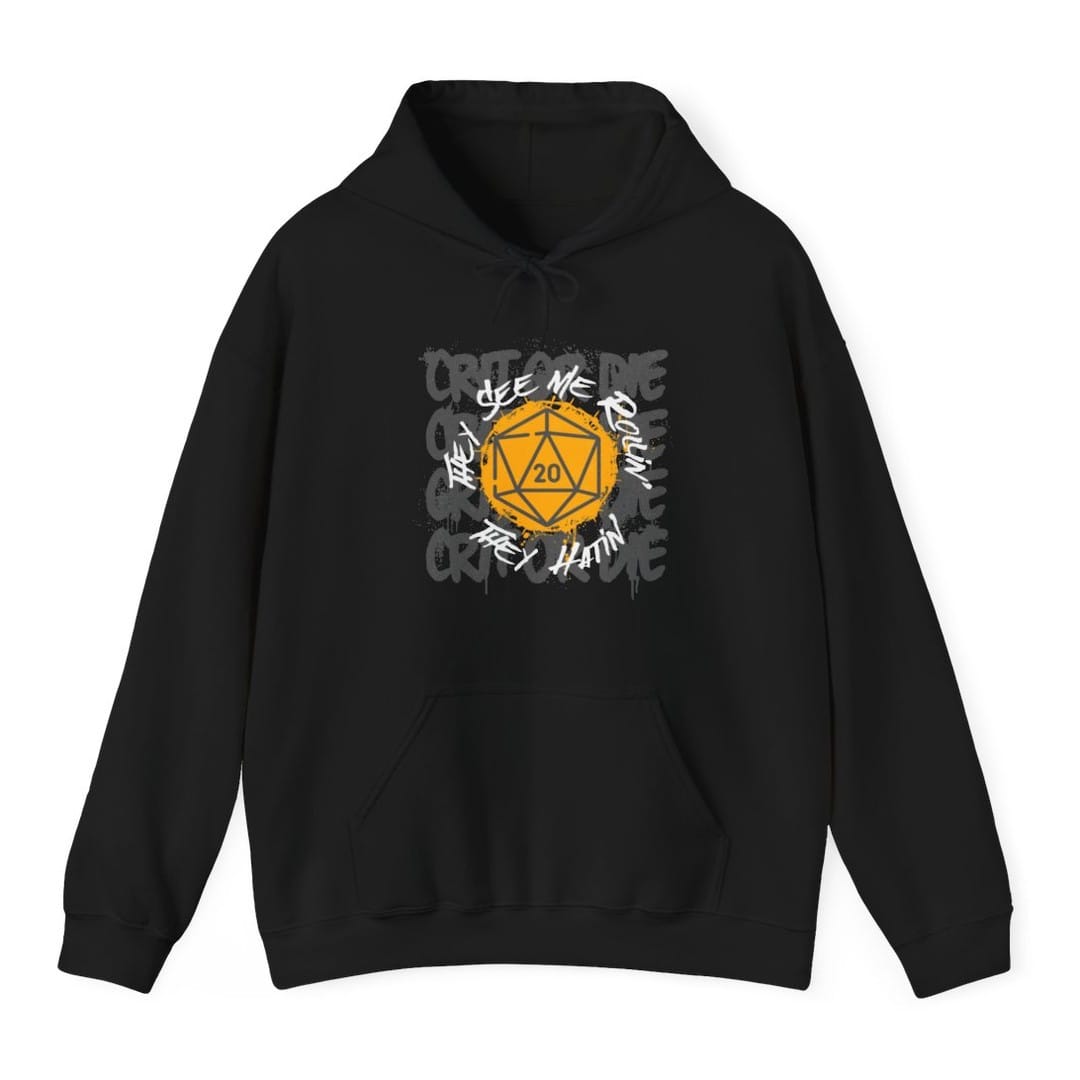 Black hoodie. A golden twenty-sided die showing 20 sits in the middle of a burst of splatter. "They see me rollin'" and "They hatin'" run diagonally across it in a rough handwritten scrawl, over a faint repeated background reading "Crit or die". Gold, white and dark gray.
